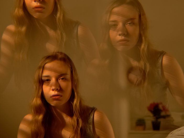 Young woman sitting on bed with enign Paroxysmal Positional Vertigo